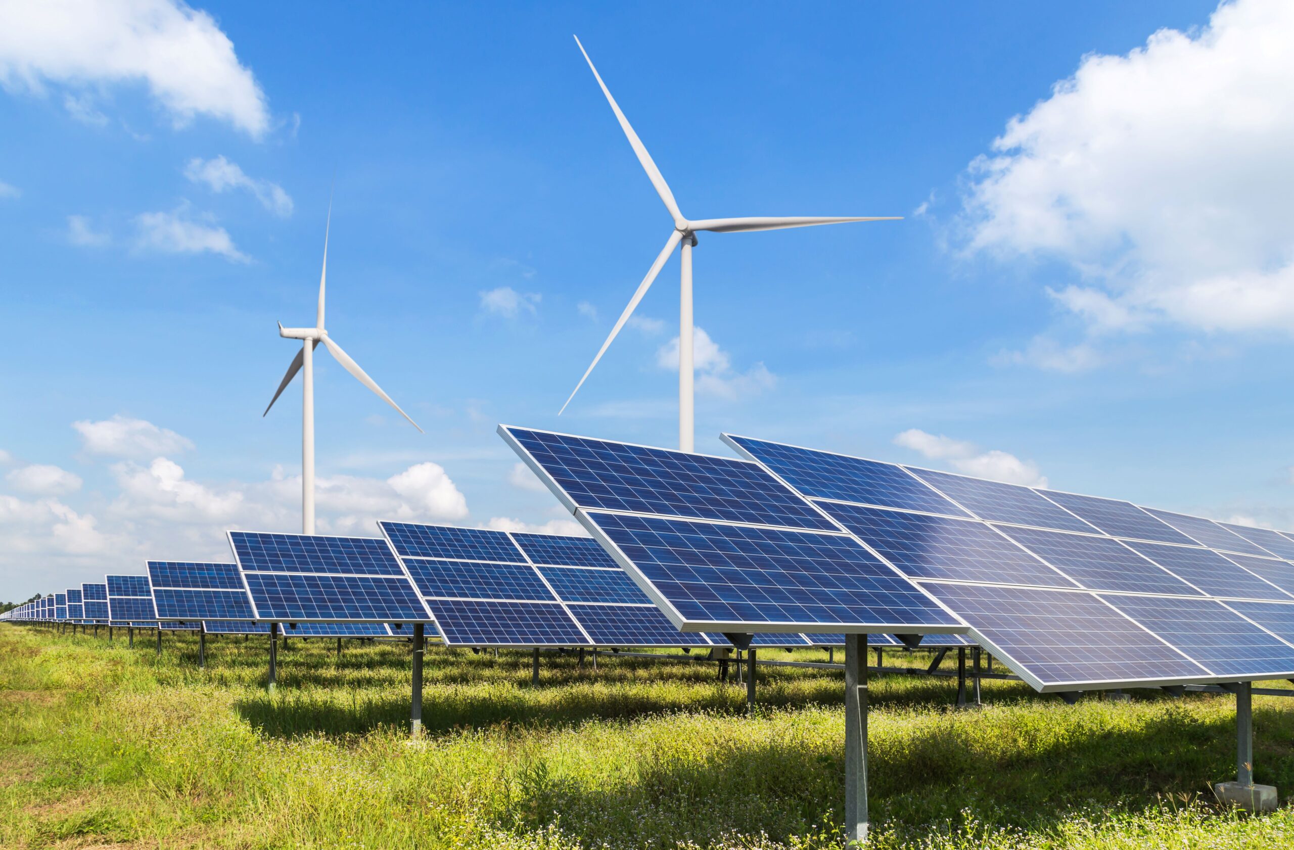 Mehrere Windräder und Solaranlagen hintereinander bei gutem Wetter