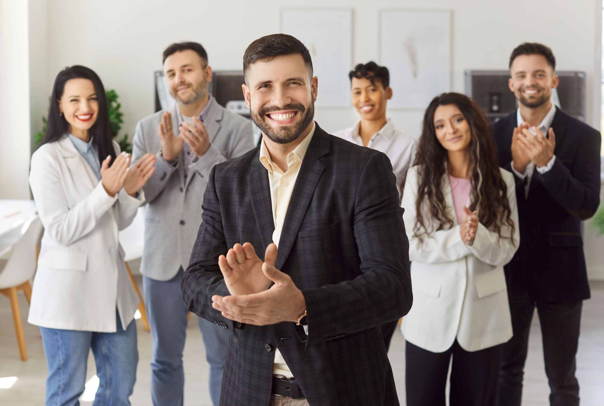 Team applaudiert im Büro – Erfolg durch Employee Assistance Program und Mitarbeitergesundheit